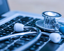 Open laptop with folded stethoscope on keyboard