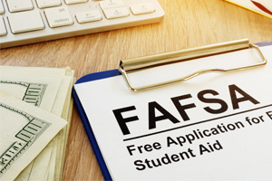 FAFSA form on desk next to calculator and paper money