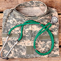 Folded military camo uniform with a green stethoscope on top